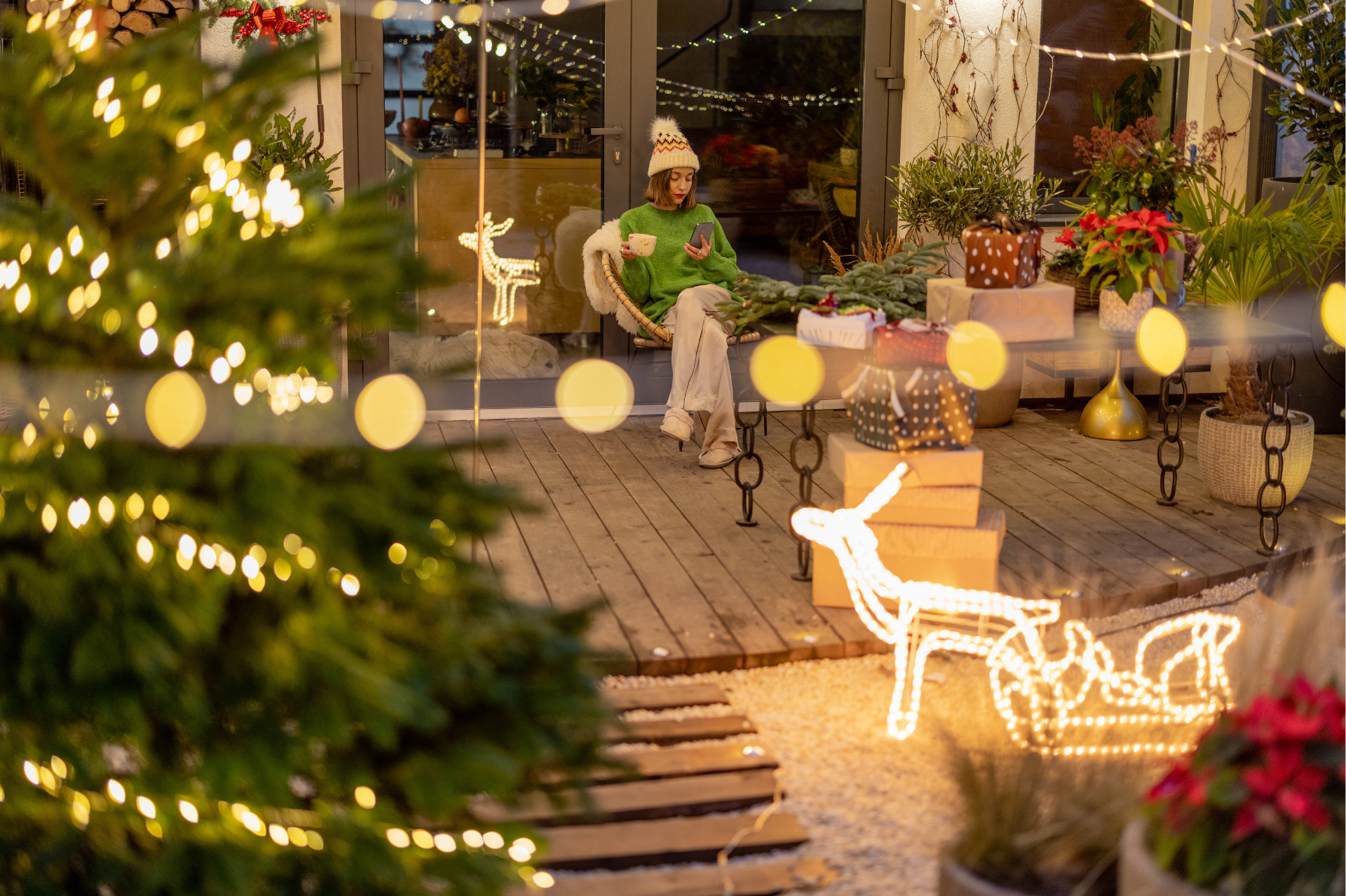 Person relaxing in her backyard with Christmas lights and decorations surrounding 